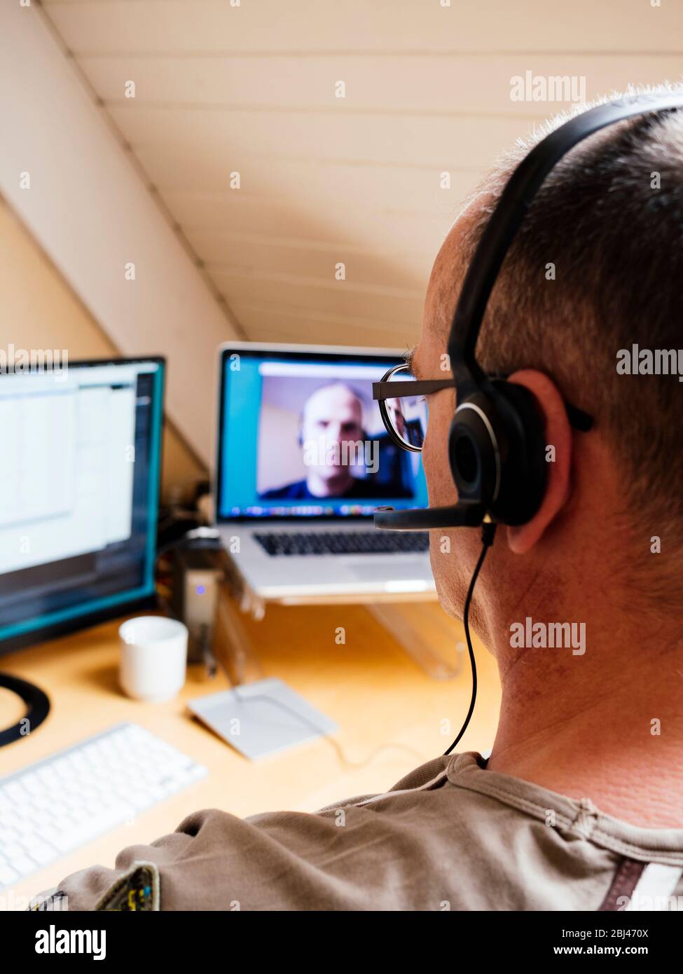 Ein Mann im Heimbüro, der einen Videoanruf mit einem Kollegen führt. Stockfoto
