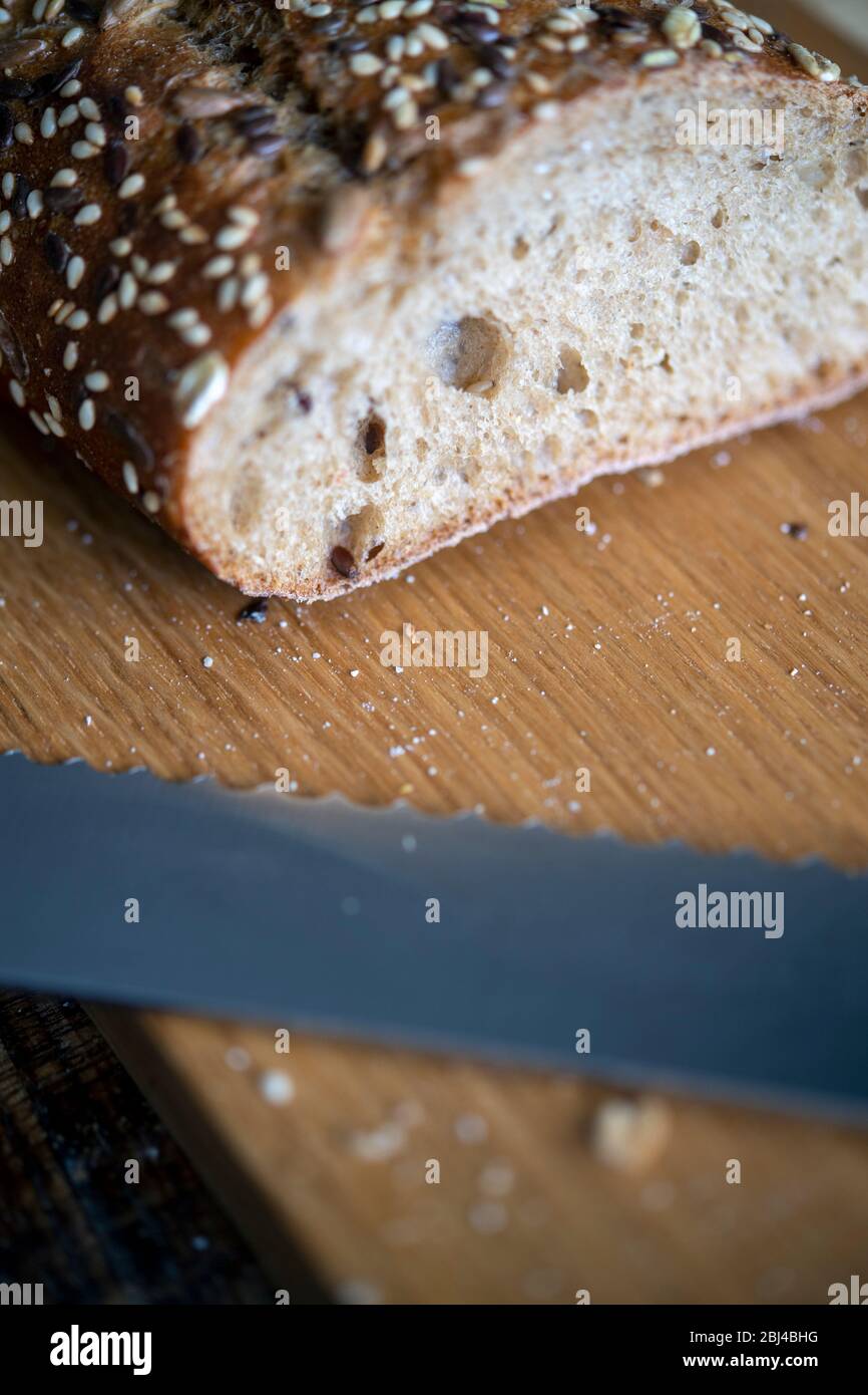 Frisch gebackener Brot und Brotmesser auf einer Schneide Platine Stockfoto