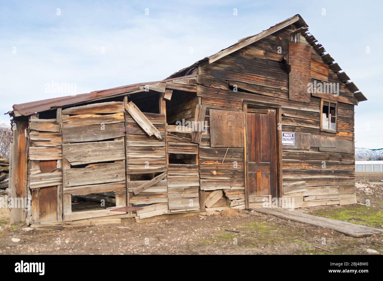Holzhütte/Scheune in verlassenem Zustand, mit verblichenem 'PRIVATEIGENTUM' Schild. Stockfoto