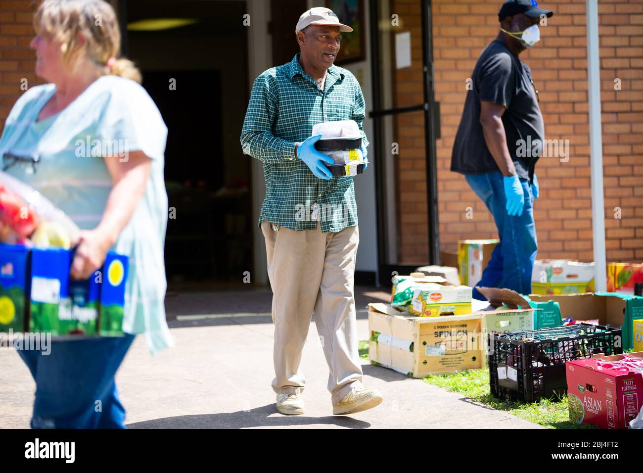 Sherman, TX / Vereinigte Staaten - 1. April 2020: Mitglieder der St. John's Christian Methodist Episcopal Church in Sherman, TX, veranstalten eine Drive-up-Speisekammer. Stockfoto