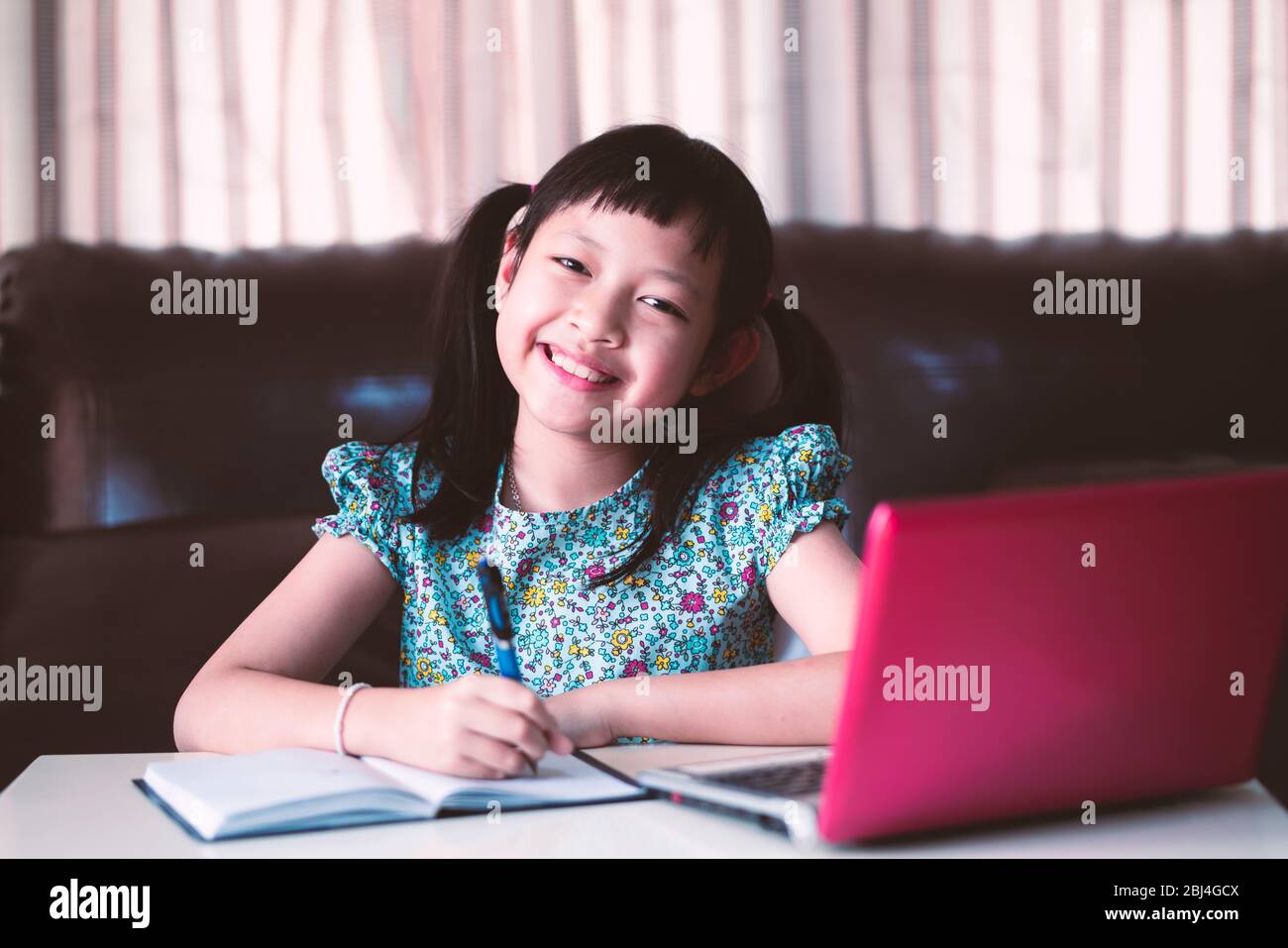 Nette asiatische kleines Kind Mädchen lernen Online-Unterricht zu Hause, soziale Distanz während der Quarantäne, Online-Bildung Konzept Stockfoto