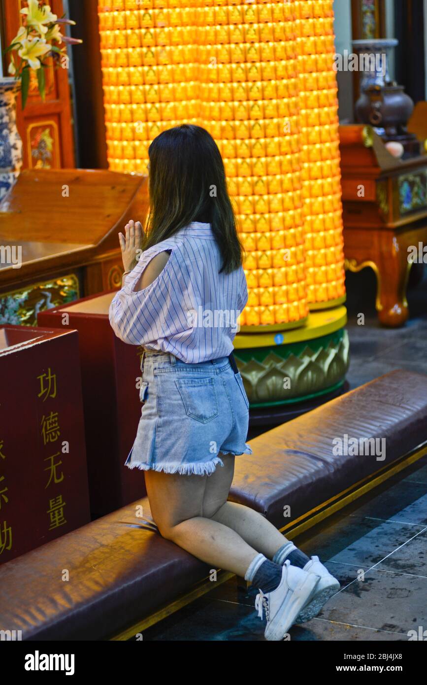 Ein junges Mädchen, das im Tempel des Stadtgottes von Shanghai (China) betet Stockfoto