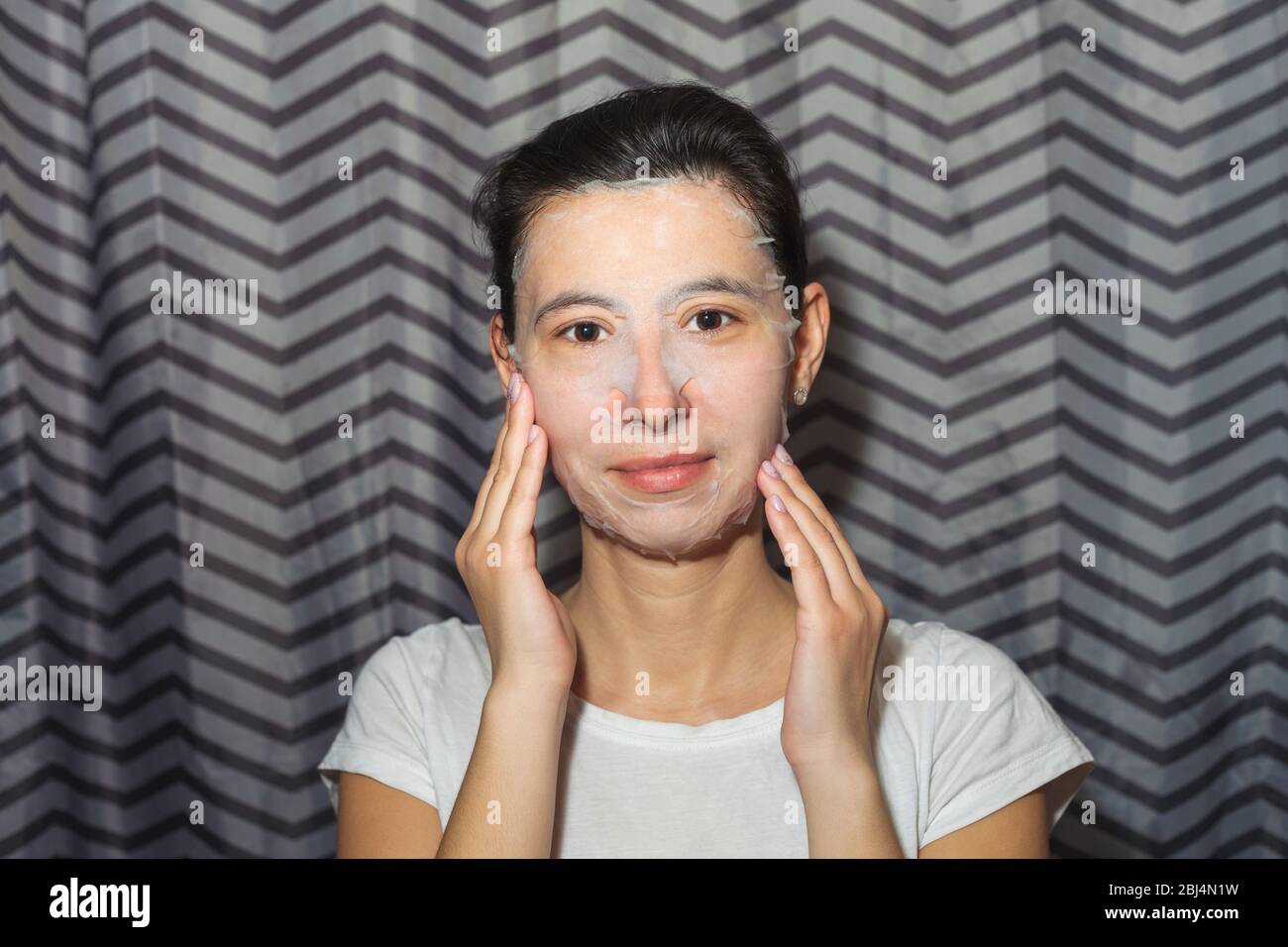 Mädchen in einer kosmetischen Gesichtsmaske. Macht hausgemachte Schönheitsbehandlungen. Nahaufnahme des Fotos Stockfoto