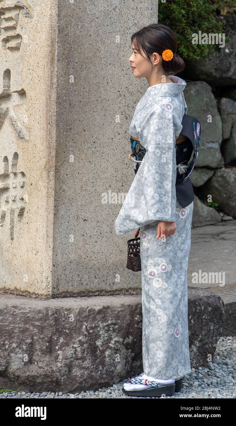 Eine Japanerin, die traditionellen Kimono trägt und die große buddha-Statue in Kamakura, Japan, besucht Stockfoto