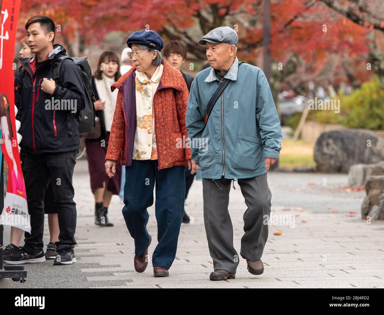 Japanische Touristen, die die Straße in Arashiyama entlang laufen. Tokio, Japan Stockfoto