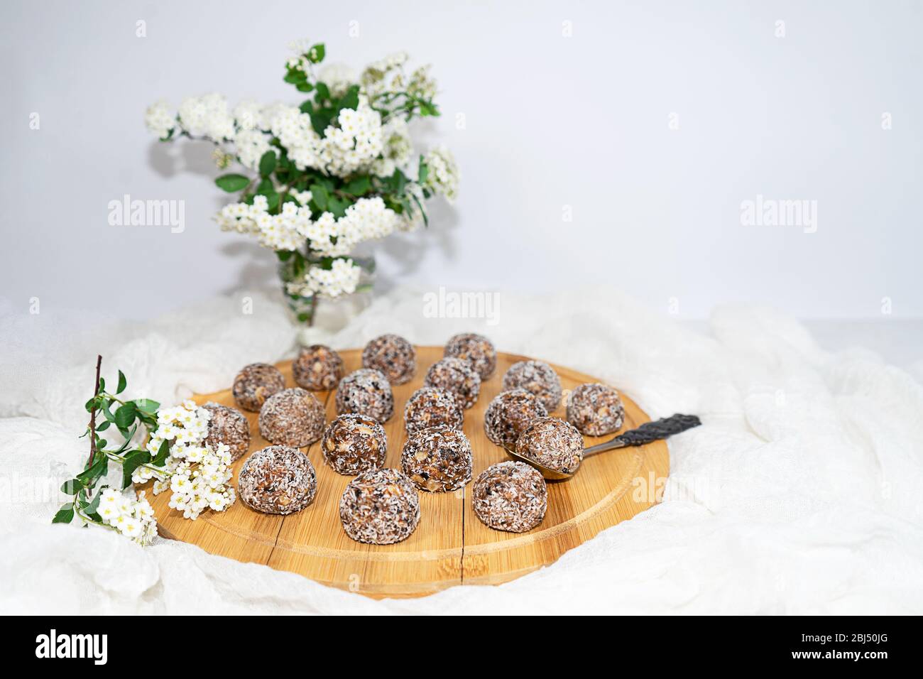 Trendy Protein Erdnussbutter Energy Bisses oder Energiebälle. Hausgemachte rohe Schokoladen-Trüffel mit Nüssen in Kokosflocken. Stockfoto