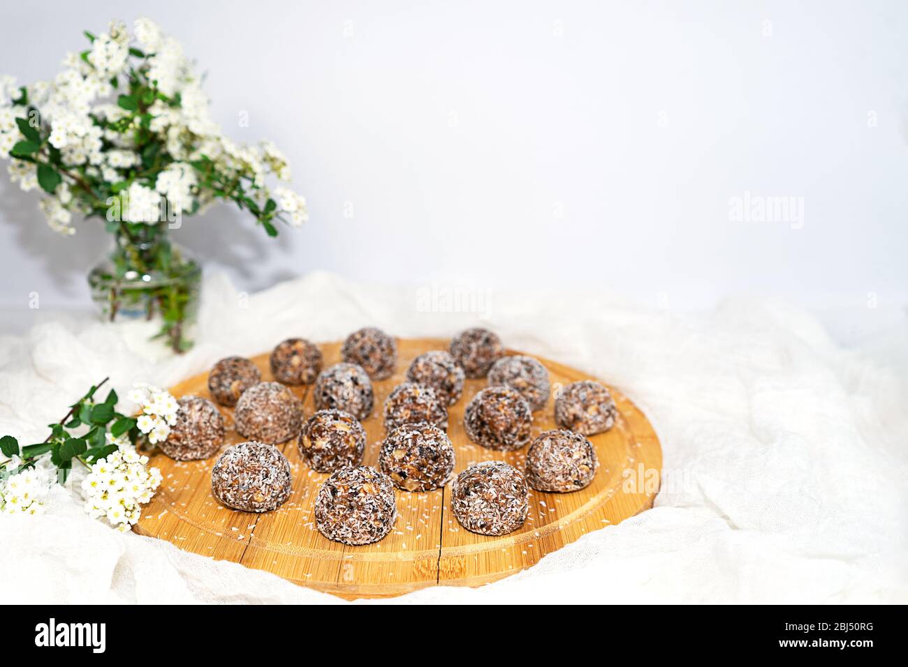 Trendy Protein Erdnussbutter Energy Bisses oder Energiebälle. Hausgemachte rohe Schokoladen-Trüffel mit Nüssen in Kokosflocken. Stockfoto