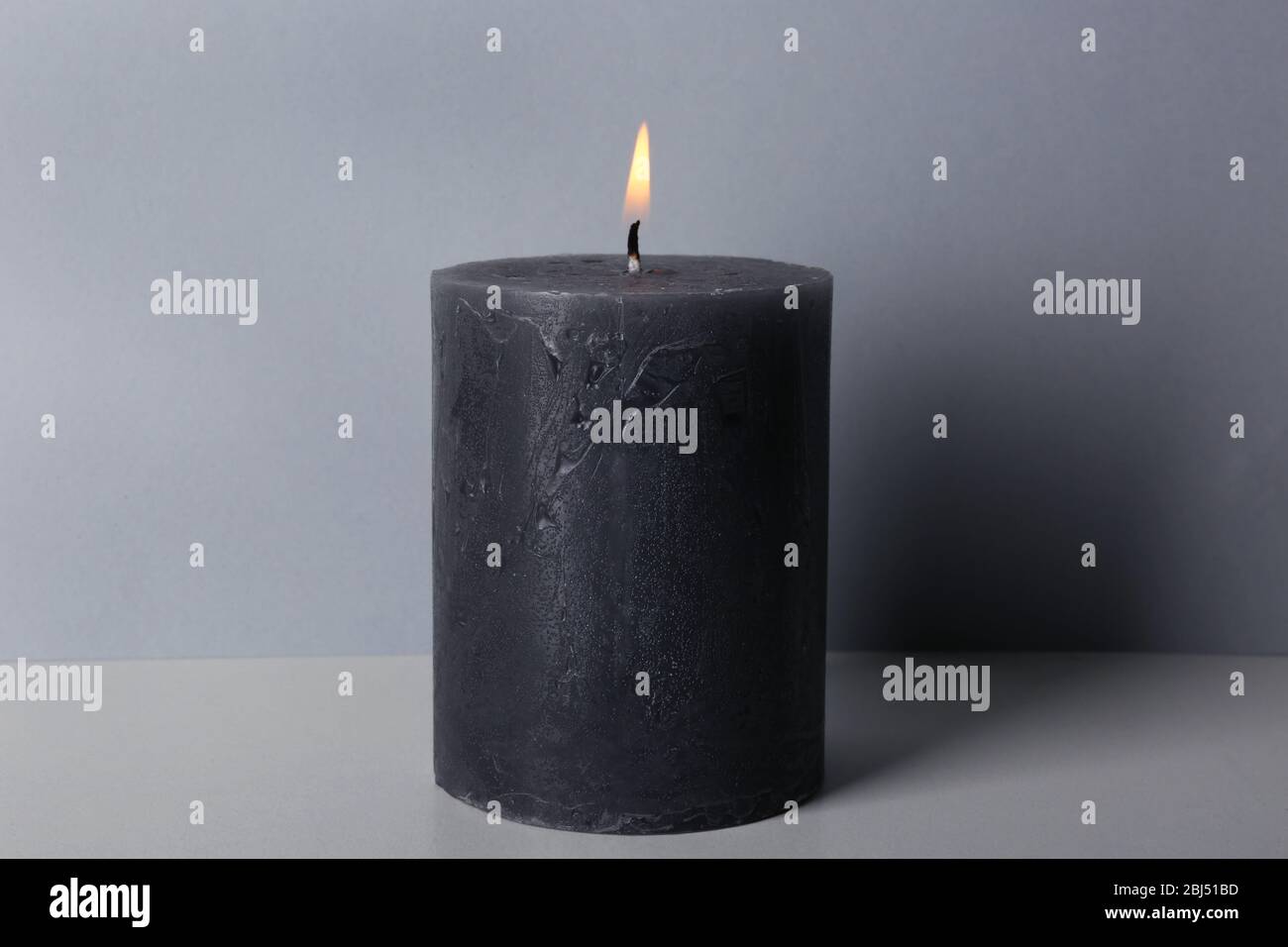 Licht Wachs graue Kerze auf hellem Hintergrund Stockfoto