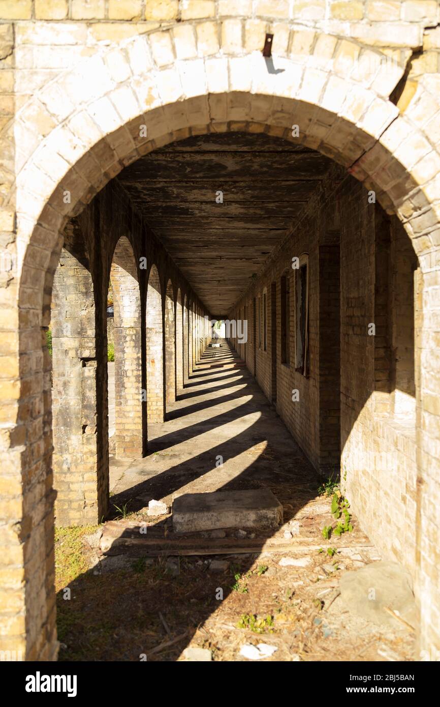 Ein langer Korridor eines alten Kolonialgebäudes, das zu einem einzigen Punkt und zum Mittelpunkt verschwindet Stockfoto