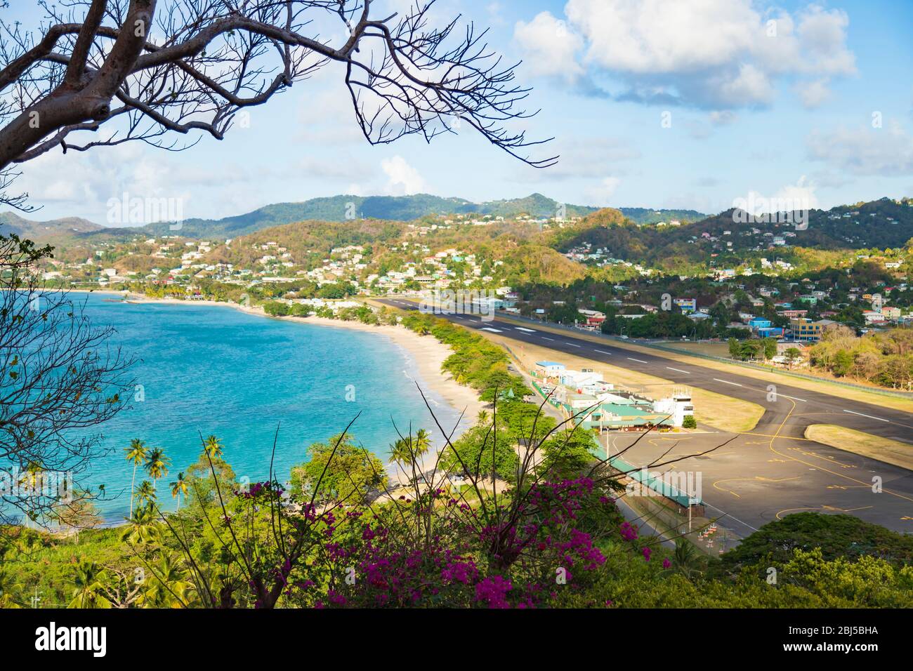Blick auf eine kleine Start- und Landebahn, das Meer und das Gebäude im Hintergrund aus einer Höhe von mehreren Metern Stockfoto