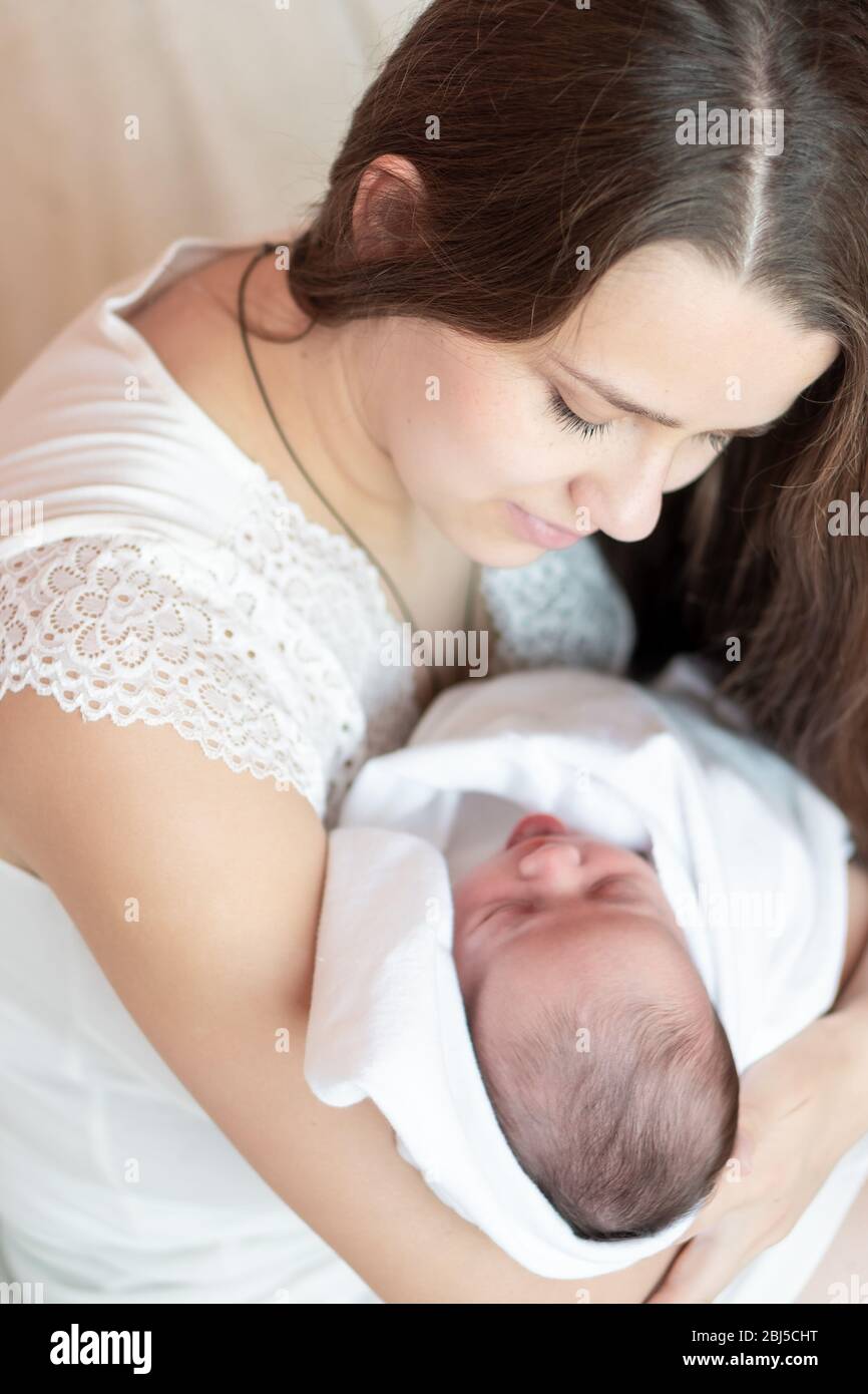 Mutterschaft, Kindheit, Familie, Pflege, Medizin, Schlaf, Gesundheit, Mutterschaft Konzept - Porträt von Mama mit neugeborenem Baby in Windel auf gewickelt Stockfoto