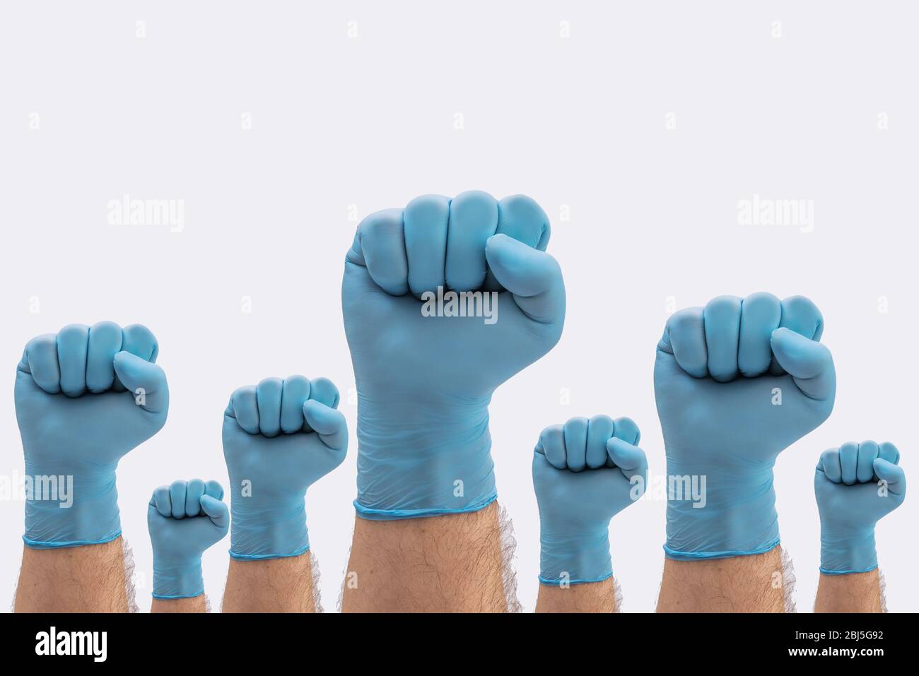Fäuste Hände in medizinischen blauen Latex Schutzhandschuhe als Zeichen der Resistenz gegen Pandemie - auf weißem Hintergrund Krankheit Zeichen zu stoppen Stockfoto
