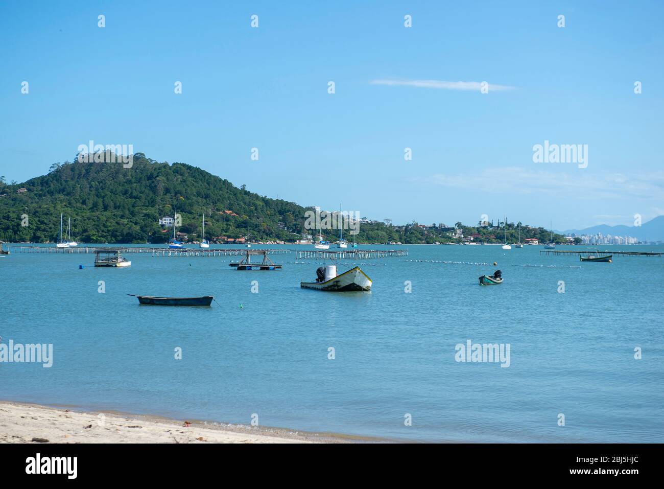 Schöne Strandlandschaft in Brasilien. Ruhiges türkisfarbenes Meer mit Fischerbooten und Segelbooten, die in der Nähe des Ufers liegen. Foto mit Platz für Text. Konzept von Stockfoto