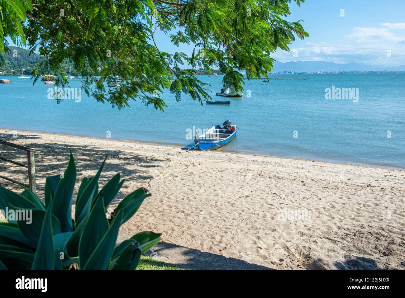 Schöne Strandlandschaft in Brasilien. Ruhiges türkisfarbenes Meer mit Fischerbooten und Segelbooten, die in der Nähe des Ufers liegen. Foto mit Platz für Text. Konzept von Stockfoto