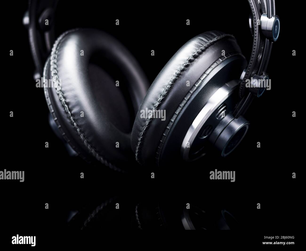 Schwarze HiFi-Kopfhörer über einer schwarzen reflektierenden Oberfläche Stockfoto