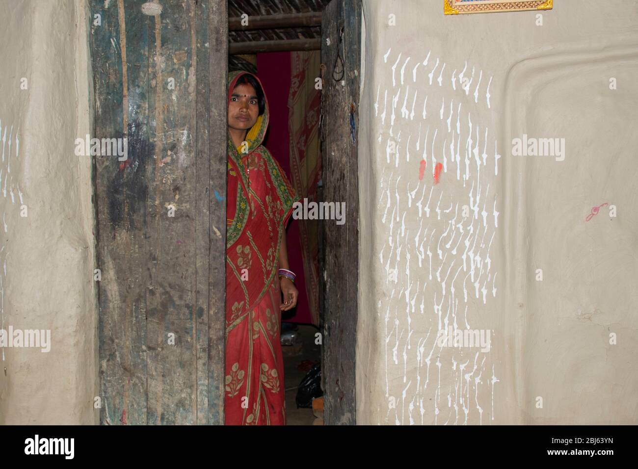 Ländliche Frau, die an der Haustüre im Dorf, Indien steht Stockfoto