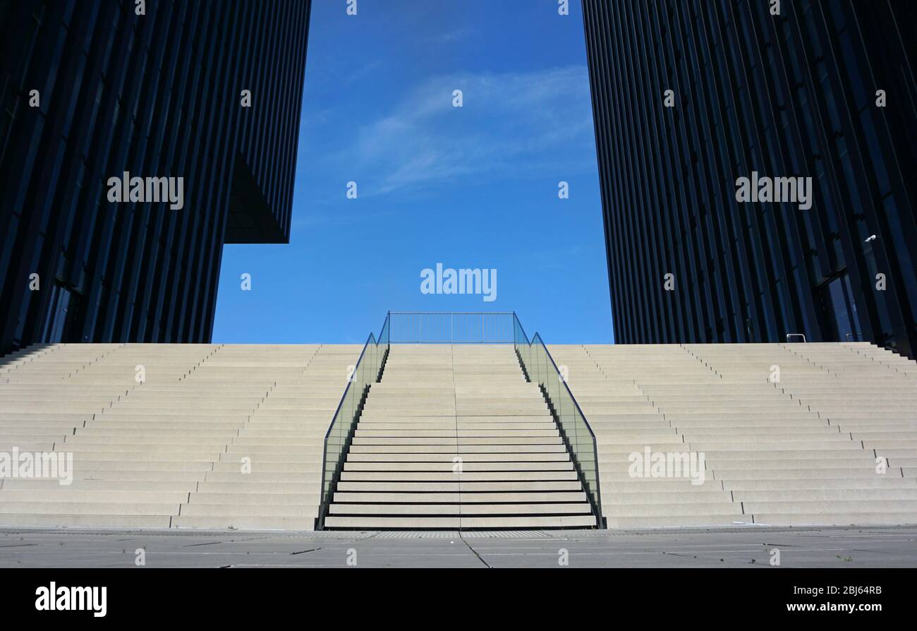 Moderne Treppe mit einem Handlauf in der Mitte, der in den blauen Himmel geht Stockfoto