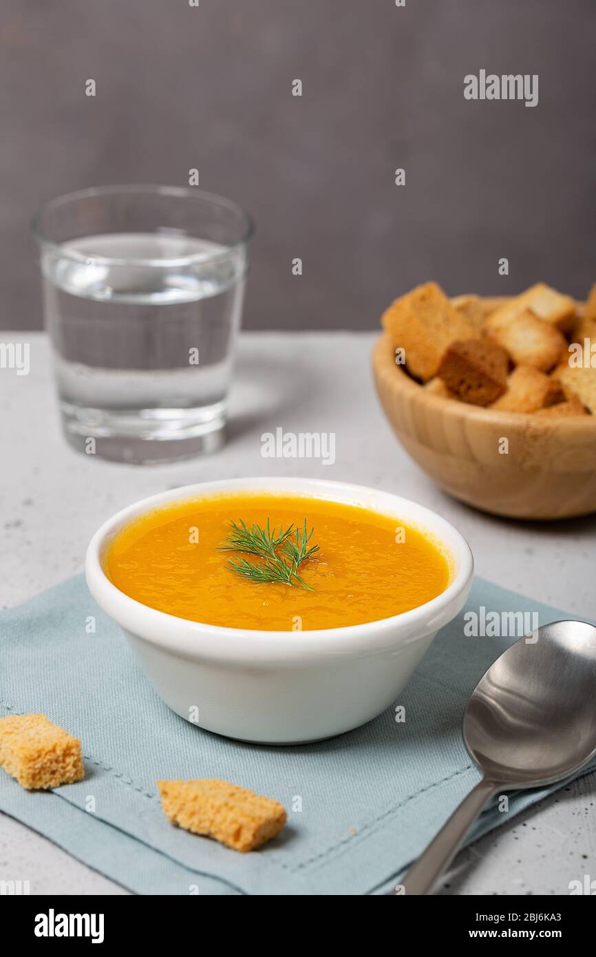 Kürbis- und Karottensuppe mit frischem Dill auf dem Tisch Stockfoto