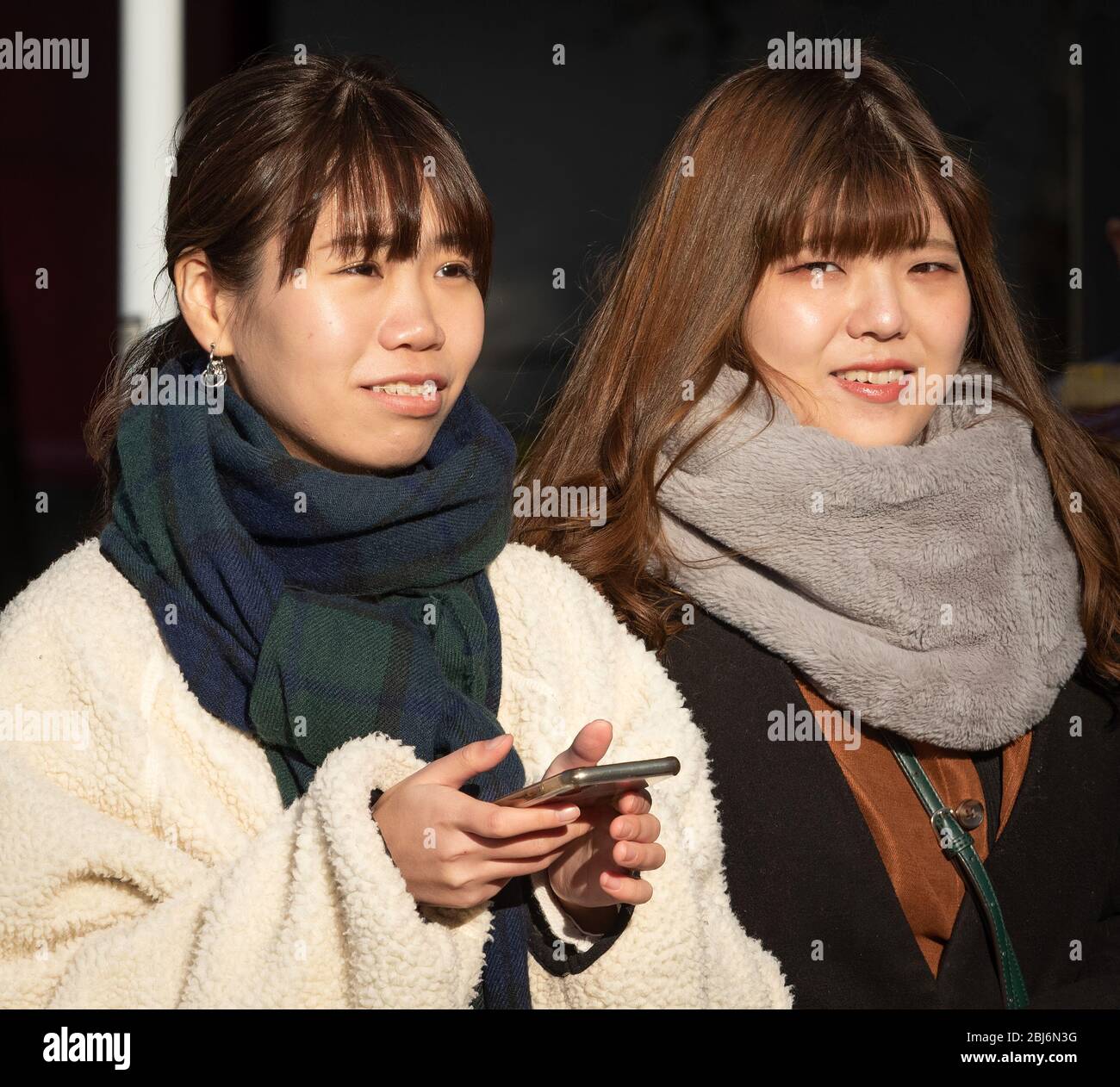 Zwei junge japanische Frauen, die im Oneo Park in Tokio, Japan, spazieren gehen Stockfoto