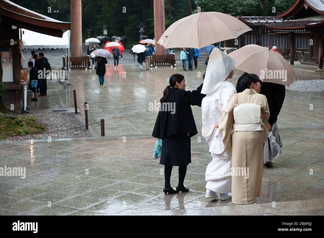 Eine japanische Braut wird von ihrer Mutter und ihren Jungfrauen am Meiji Jingu Schrein, Tokyo Japan, besucht Stockfoto