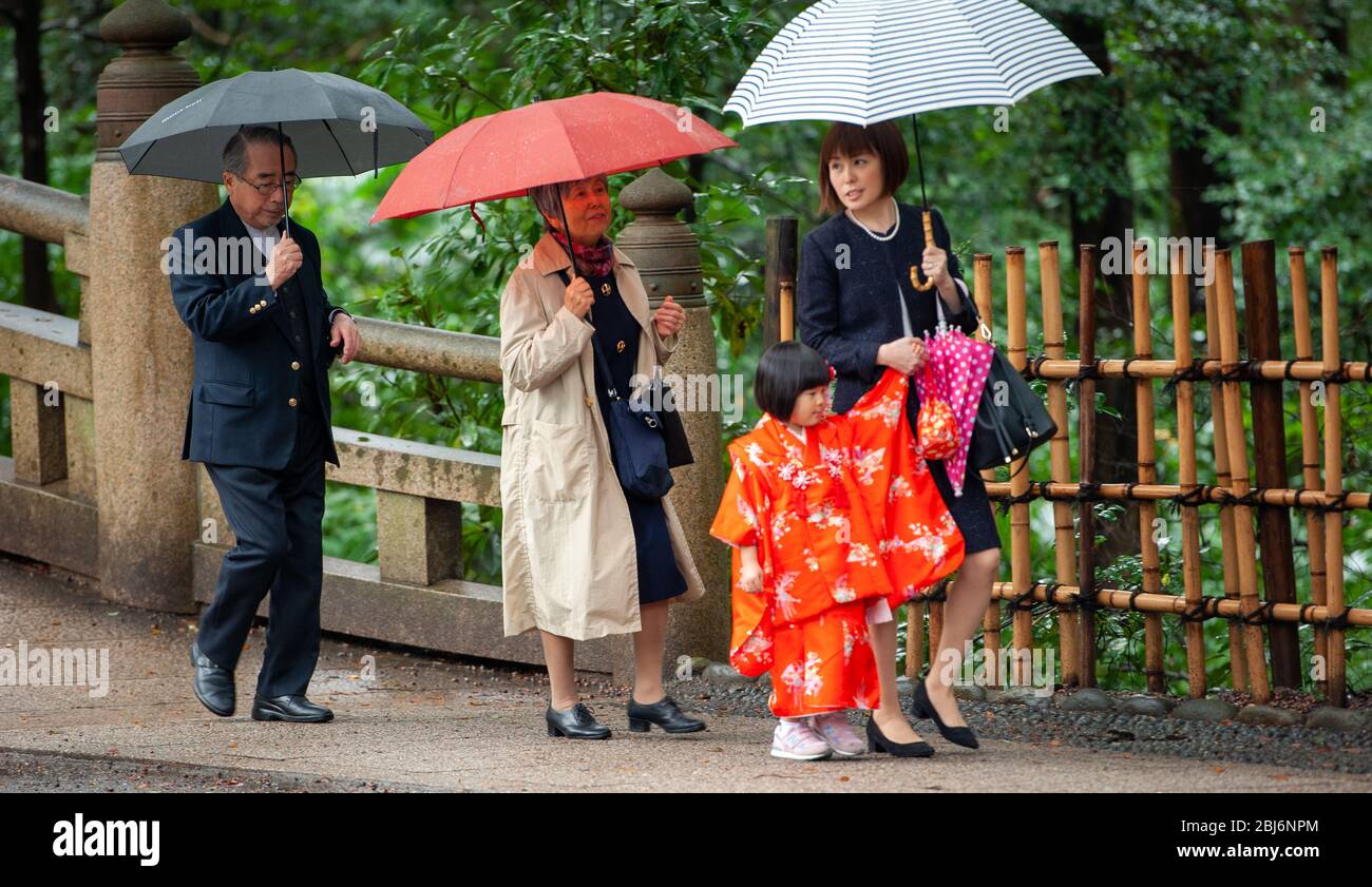 Eine japanische Familie läuft an einem regnerischen Tag zum Meiji-Schrein in Tokio, Japan Stockfoto