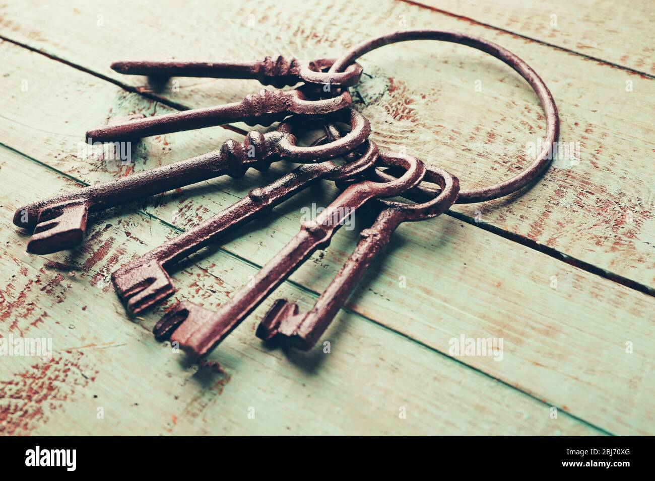 Haufen alter Schlüssel auf blauem Holzhintergrund, Nahaufnahme Stockfoto