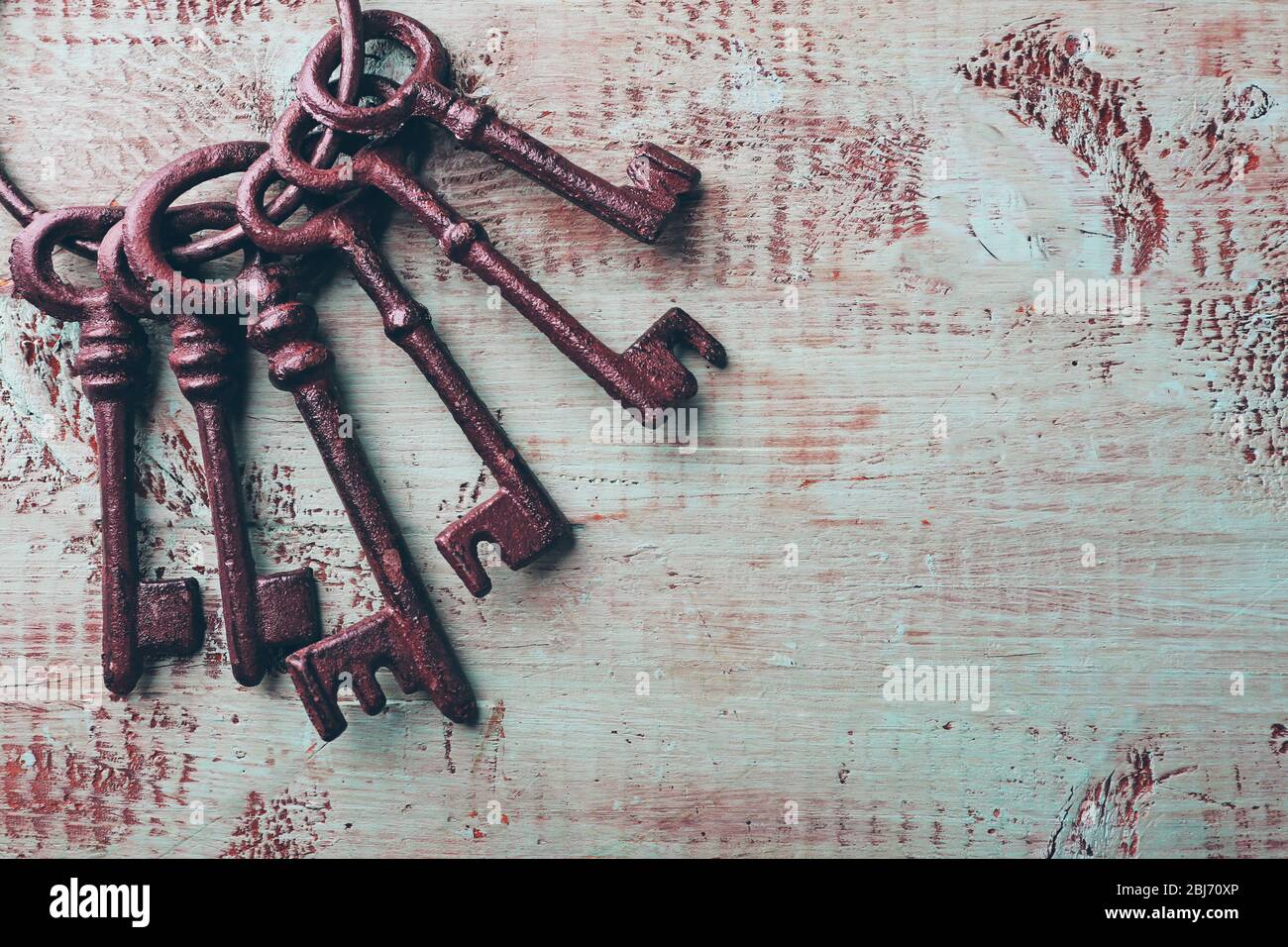 Haufen alter Schlüssel auf blauem Holzhintergrund, Nahaufnahme Stockfoto