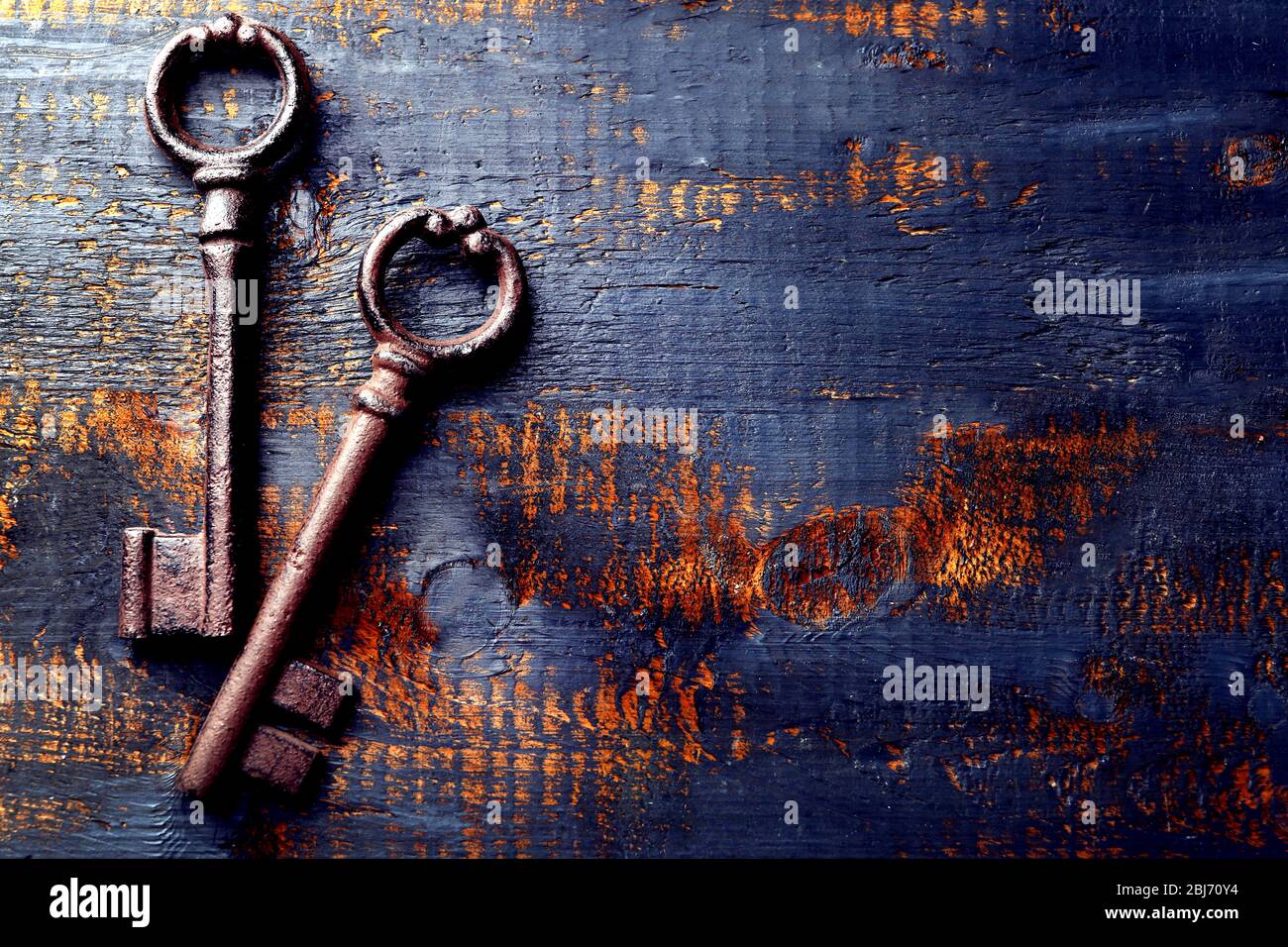 Alte Schlüssel auf blauem, zerkratztem Holzhintergrund, Kopierraum Stockfoto