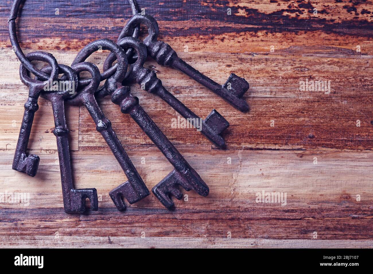 Haufen alter Schlüssel auf Holzhintergrund, Nahaufnahme Stockfoto