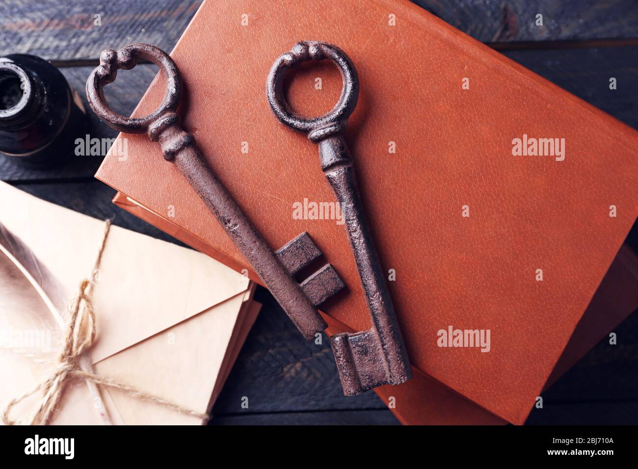 Haufen alter Schlüssel mit Notizbüchern auf dunklem Holzhintergrund, Nahaufnahme Stockfoto
