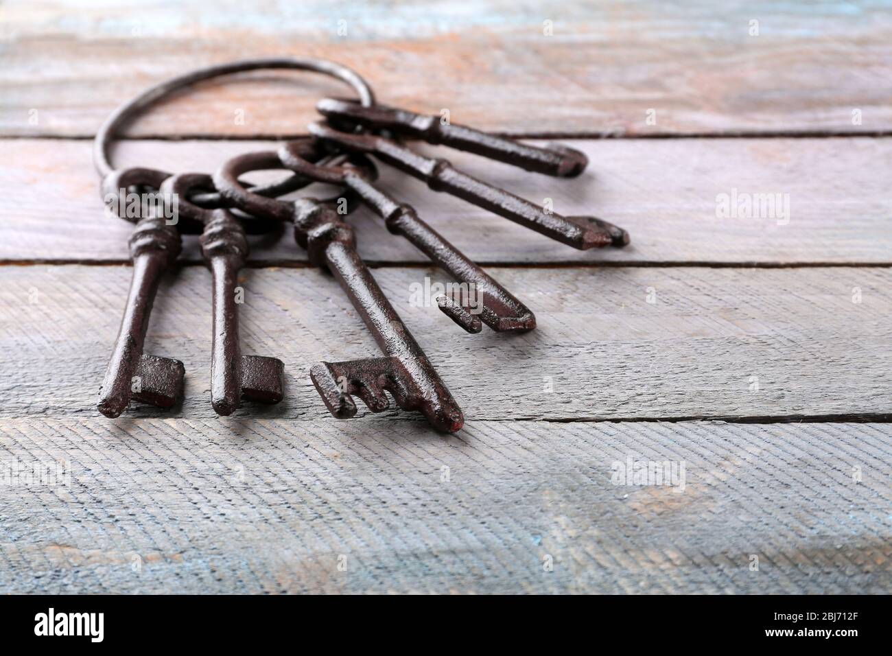 Haufen alter Schlüssel auf Holzhintergrund, Nahaufnahme Stockfoto