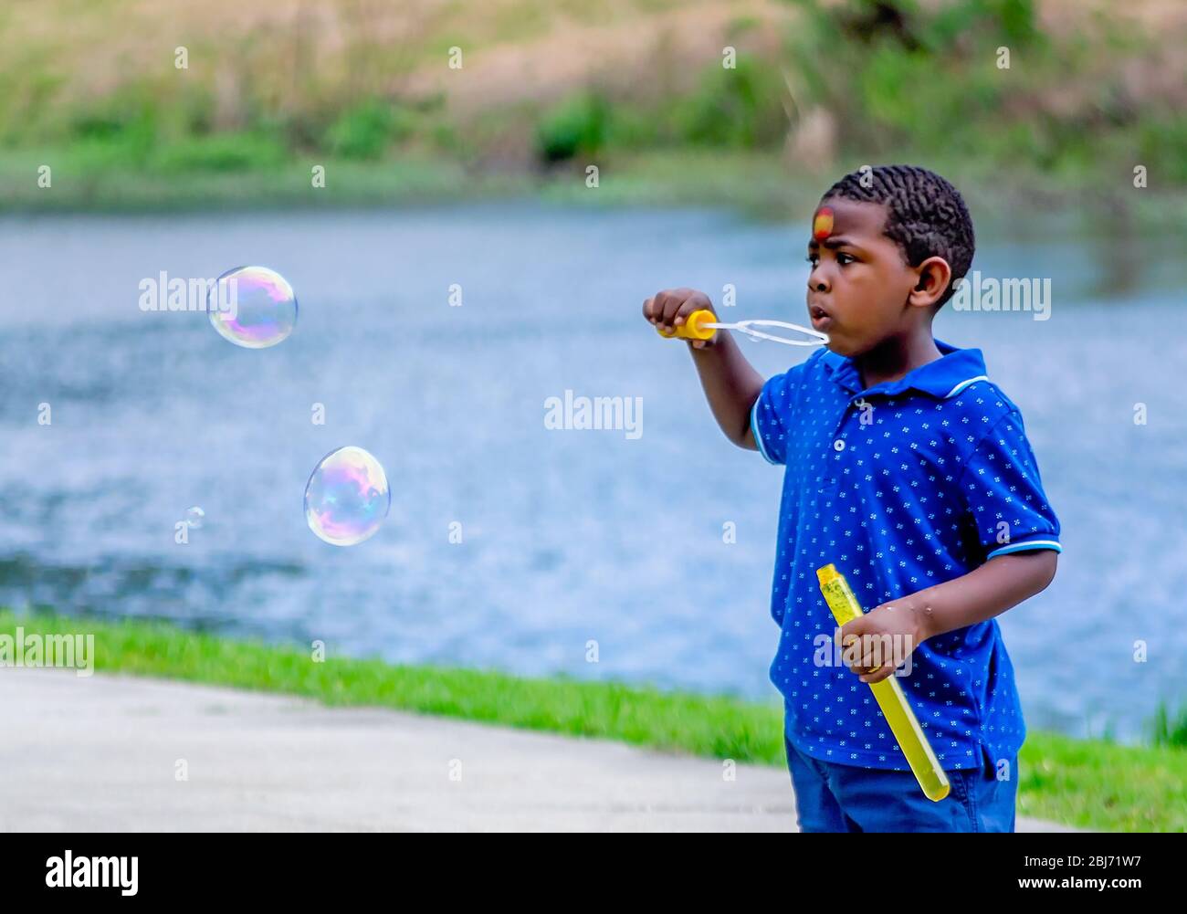 Ein Junge bläst Blasen im Langan Park, 13. April 2019, in Mobile, Alabama. Der 720 Hektar große Park bietet eine Vielzahl von Freizeitmöglichkeiten. Stockfoto