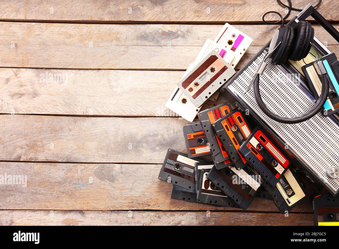 Kassettenrecorder und Retro-Kassette mit Kopfhörern auf Holztisch, Kopierraum Stockfoto