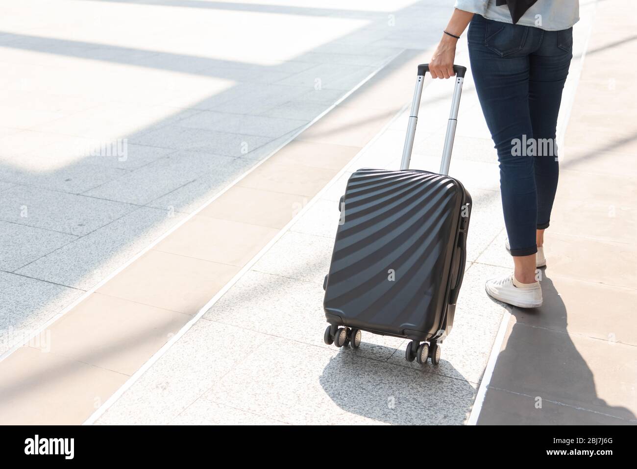 Nahaufnahme Frau und Koffer Trolley Gepäck im Flughafen. Menschen und  Lebensstile Konzept. Thema Reise und Geschäftsreise. Frau trägt Jeans, die  auf Tour gehen Stockfotografie - Alamy