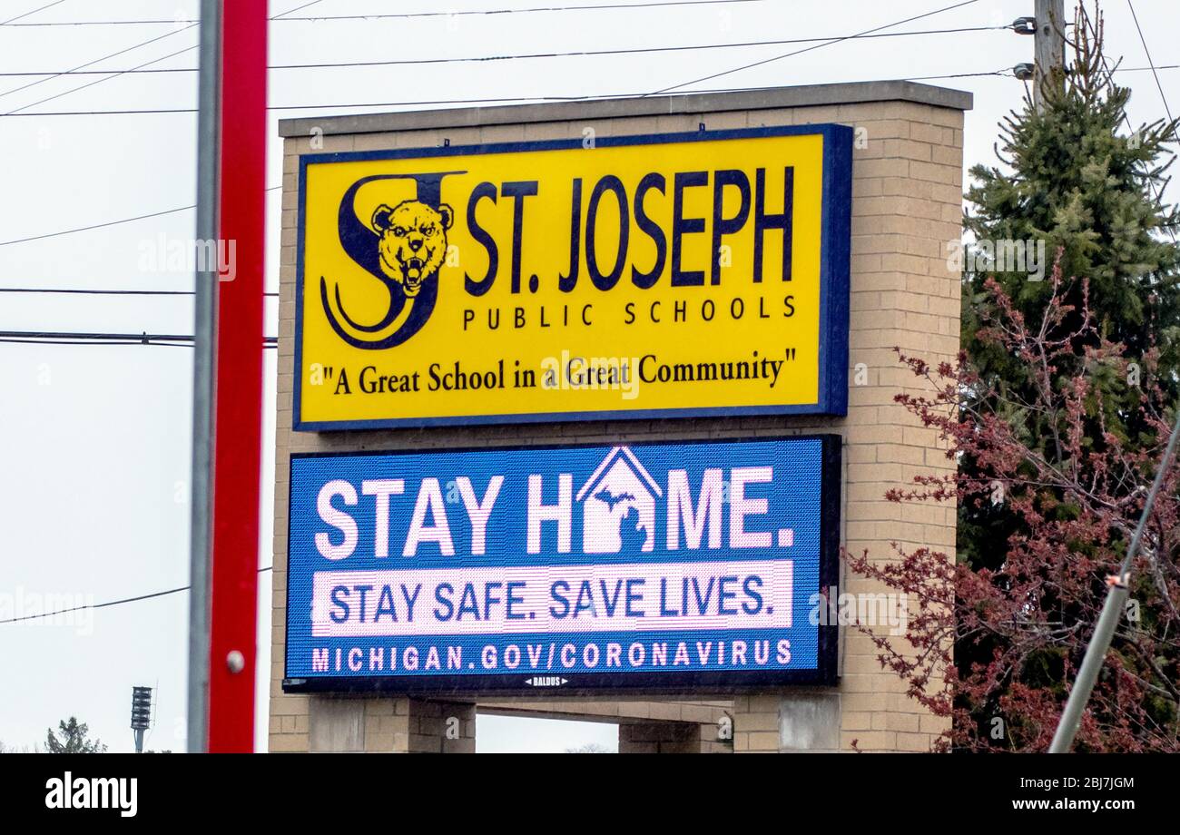 St. Joseph MI USA April 23 2020; EIN Schild für öffentliche Dienste auf einer lokalen High School erinnert die Menschen in Michigan daran, zu Hause zu bleiben und unter öffentlicher Distanz sicher zu bleiben Stockfoto