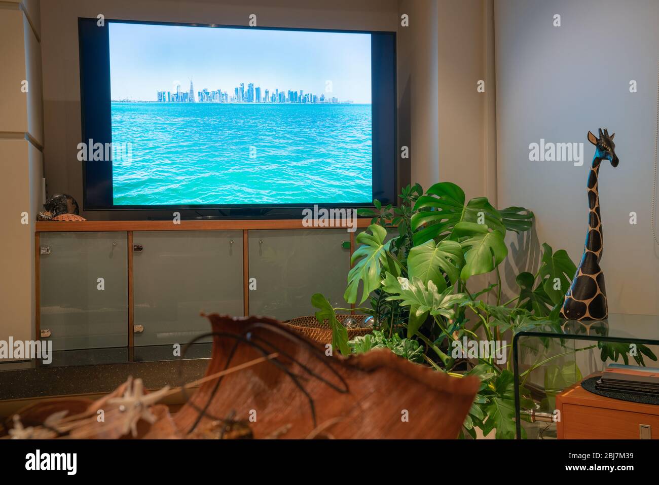 Home Interior Bild trendige Dekoration und Pflanzen mit Doha Skyline Bild auf dem Fernsehbildschirm. Stockfoto