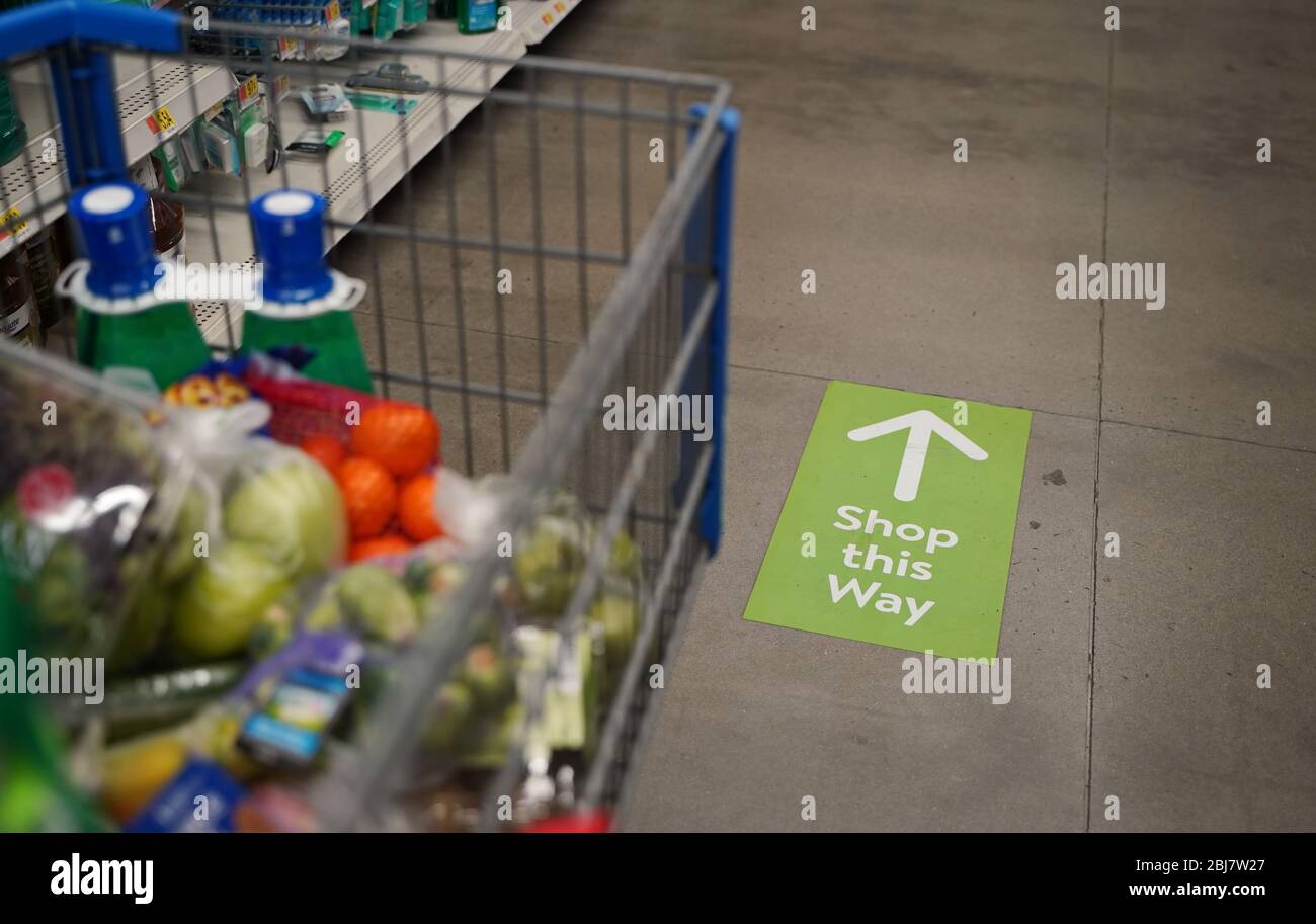 Cromwell, CT / USA - April 20, 2020: Neue Schilder in Walmart führen den Einkaufenverkehr durch Einbahngänge, um Gedränge zu vermeiden, eine neue Normalität während Stockfoto