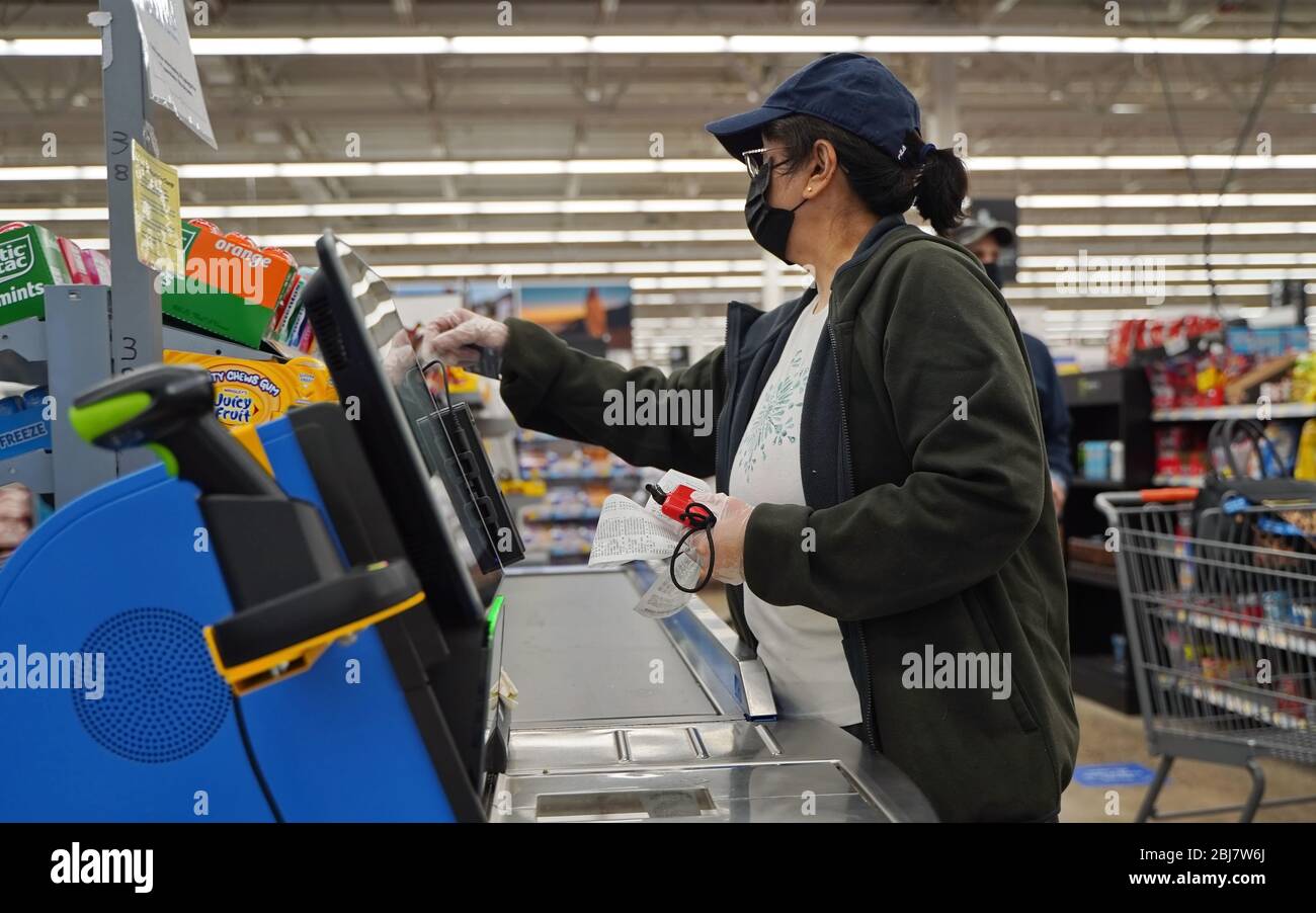 Cromwell, CT / USA - 20. April 2020: Maskierte und geliebte Frau nutzt den Self Checkout Stockfoto