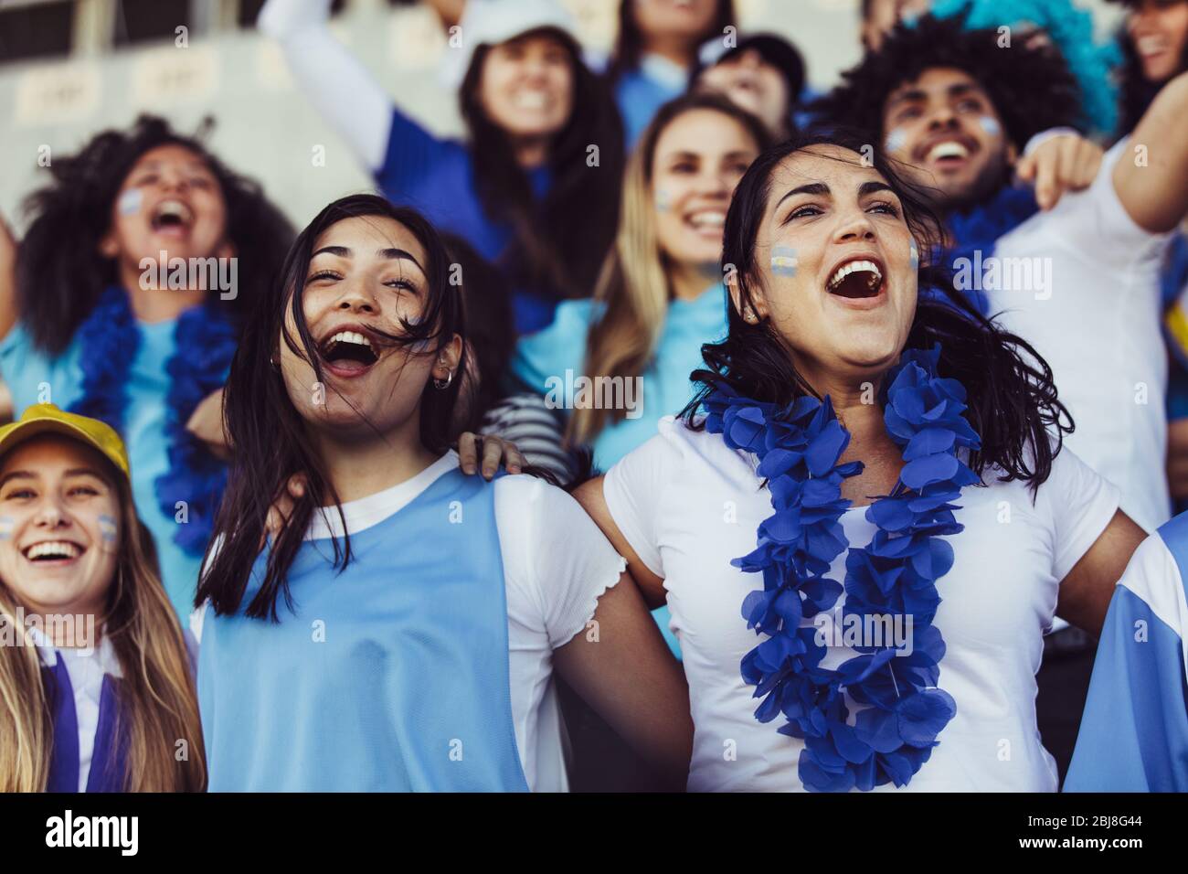 Argentinische Fußballfans jubeln ihre Mannschaft mit einer blauen Girlande im Stadion an. Begeisterte Fußballfans im Stadion jubeln ein Tor. Stockfoto