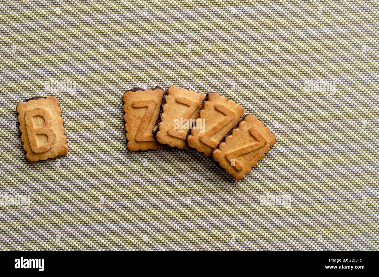 Schriftzug BZZZ Cookie Alphabet aus Cookies. Fünf Großbuchstaben auf einem rechteckigen Plätzchen. Blick von oben. Nahaufnahme. Selektiver Fokus. Stockfoto