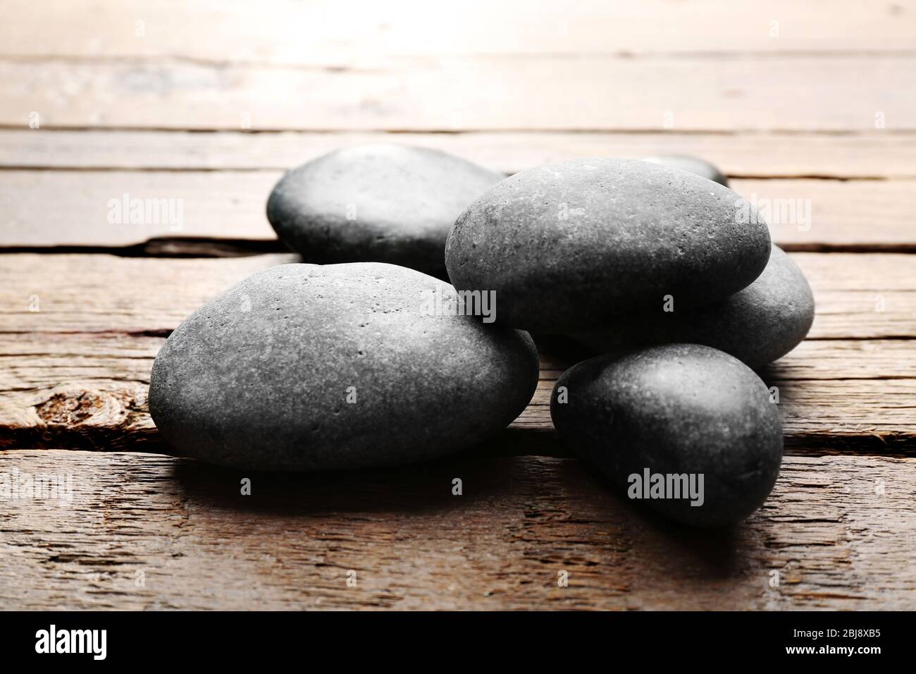 Haufen von heißen Steinen auf Holztisch Stockfoto