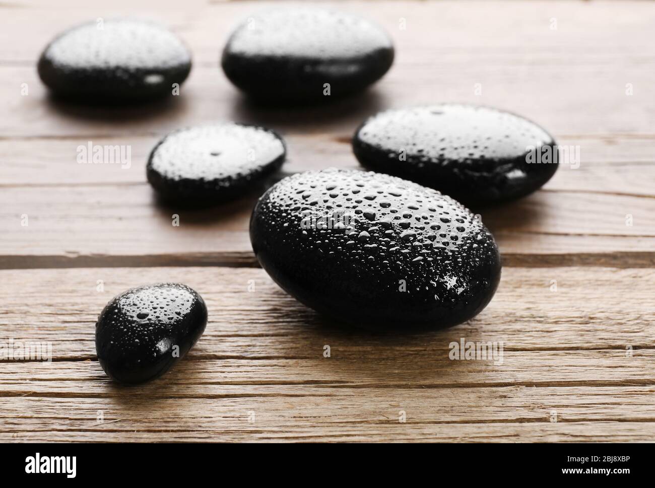 Haufen von heißen Steinen auf Holztisch Stockfoto