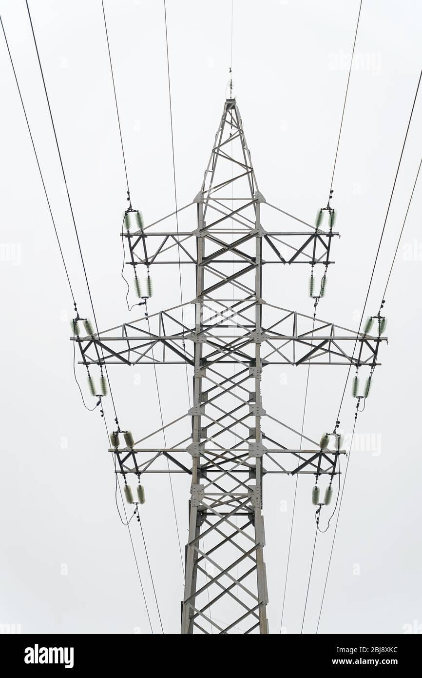 Stromübertragungsleitungen, Strommast vor dem Hintergrund eines hellen, fast weißen Himmels. Hochspannungsturm Stockfoto