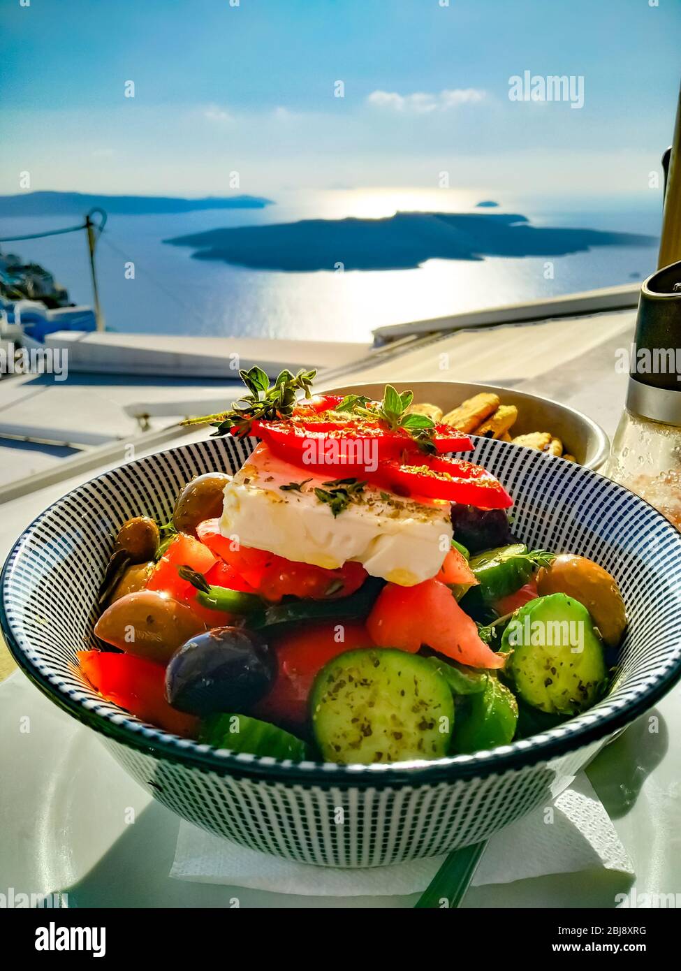 Sehr leckerer griechischer Salat mit einem fantastischen Blick auf den Vulkan Santorini, Griechenland Stockfoto