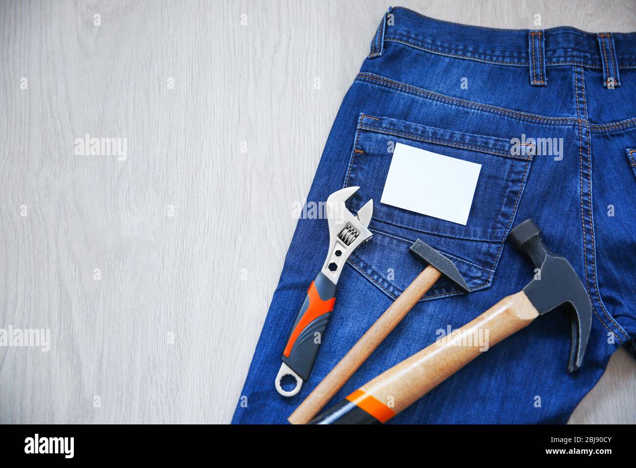 Bauwerkzeuge und Jeans auf Holzhintergrund. Konzept des Labor Day Stockfoto