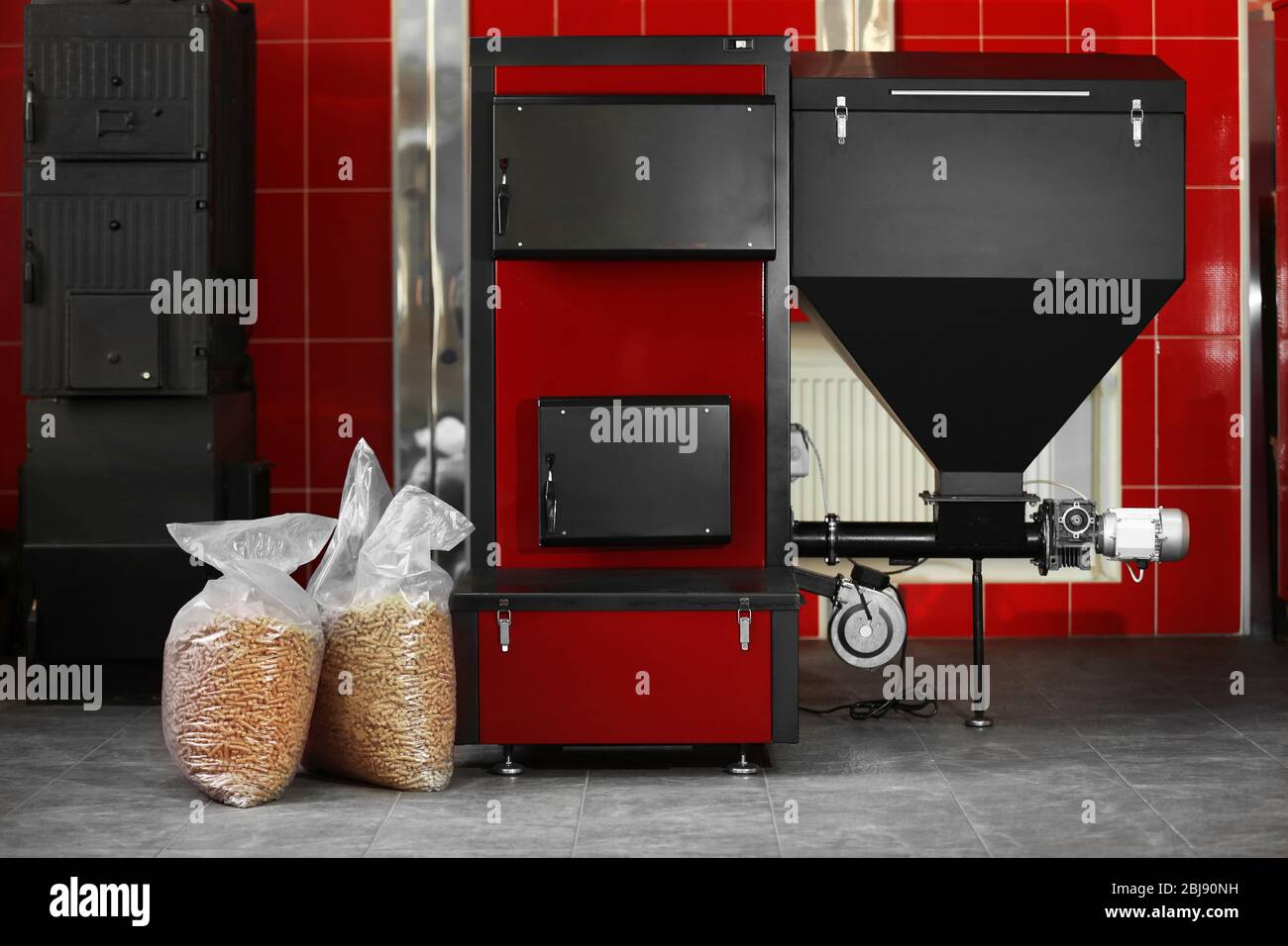 Festbrennstoffkessel mit Pelletbrennstoff im Kesselraum Stockfoto