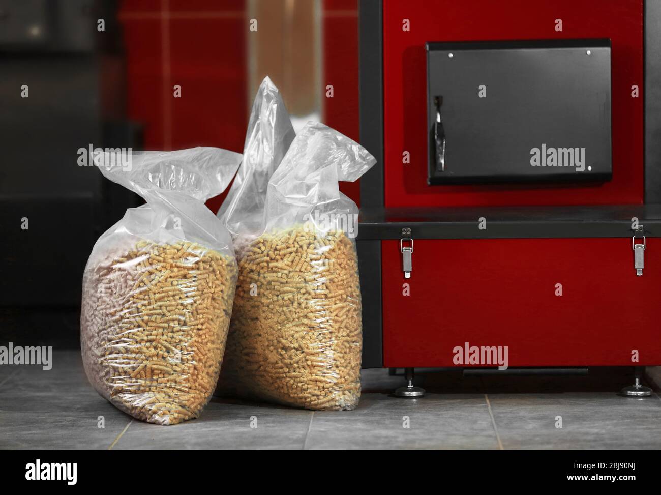 Festbrennstoffkessel mit Pelletbrennstoff im Kesselraum Stockfoto