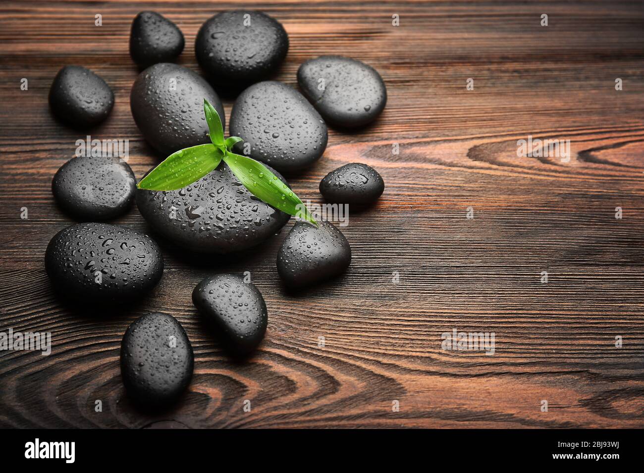 Haufen von heißen Steinen auf Holzhintergrund Stockfoto