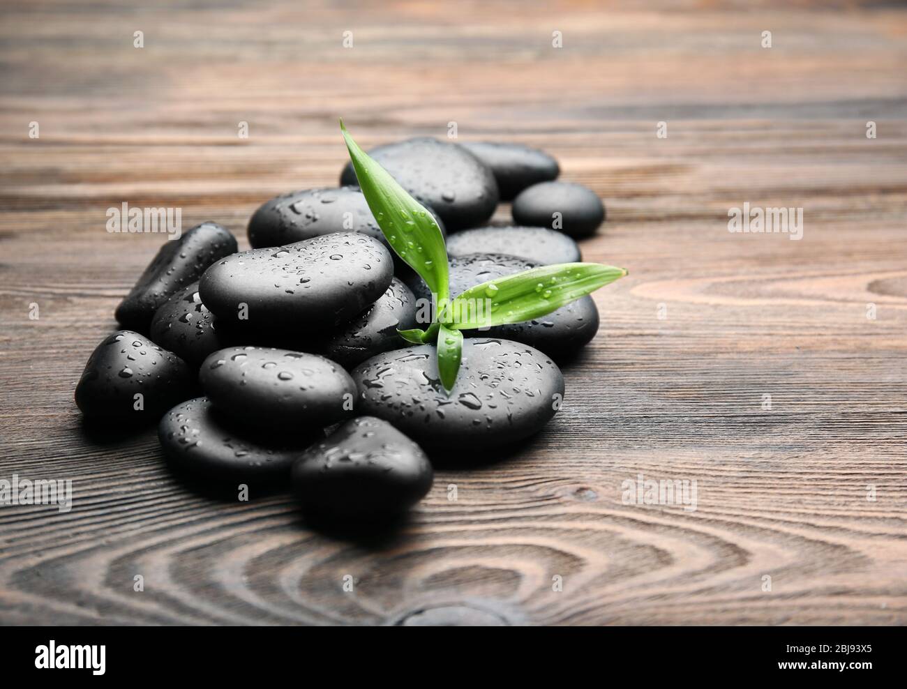 Haufen von heißen Steinen auf Holzhintergrund Stockfoto