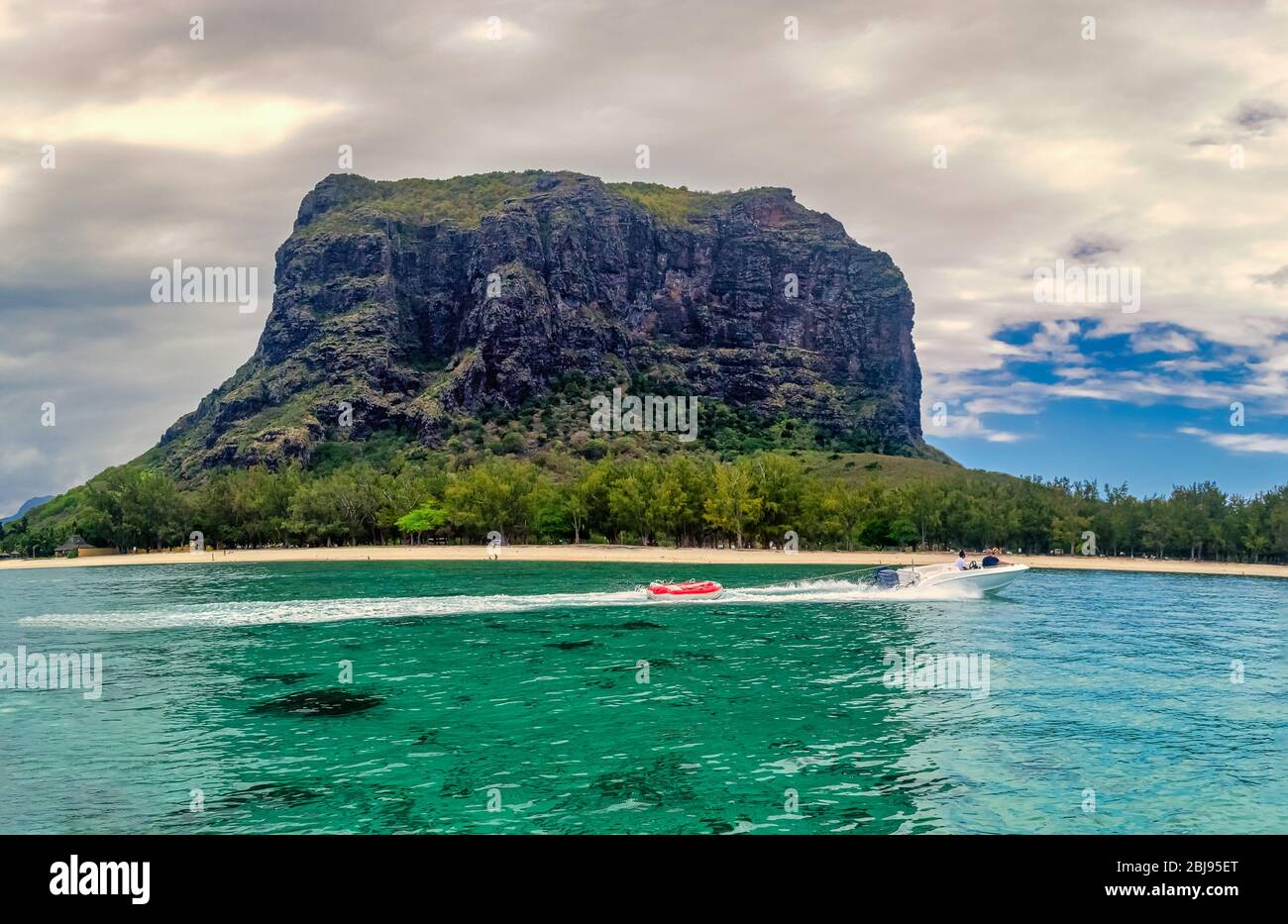 Ein Schnellboot vor dem beliebten Berg Le Morne Brabant der afrikanischen Trauminsel Mauritius. Stockfoto